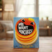 Card game box titled 'Me Want Pancakes!' on a wooden table with a blurred indoor background