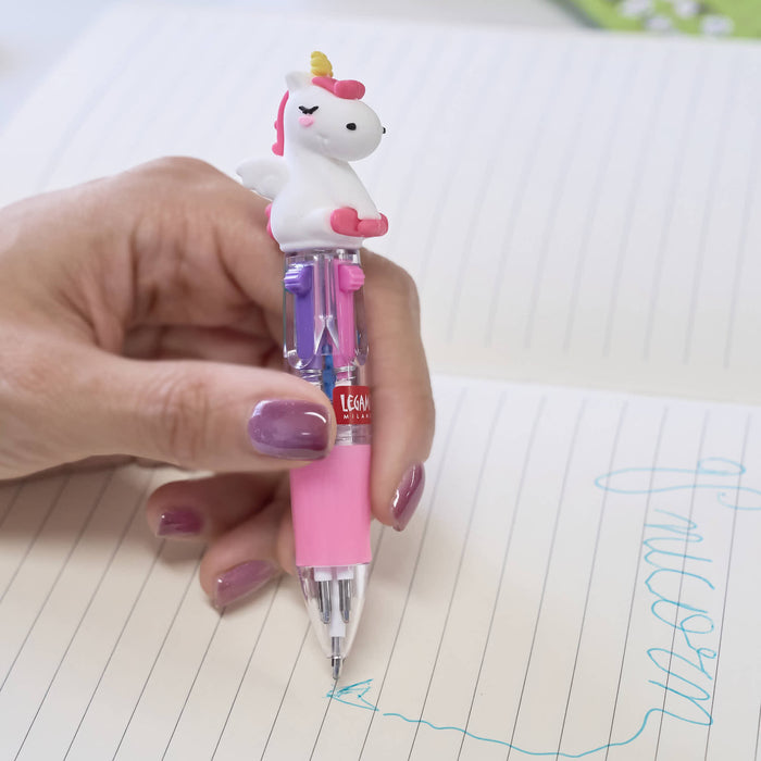 Hand holding a pink cartoon unicorn pen over a notebook