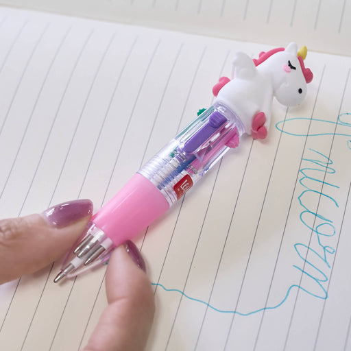 Unicorn-shaped pen with colorful accents on a lined notebook page