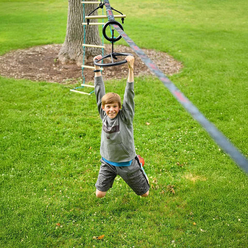 Child playing on a rope ladder in a grassy area