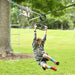 Child playing on a playground rope ladder and rings in a park
