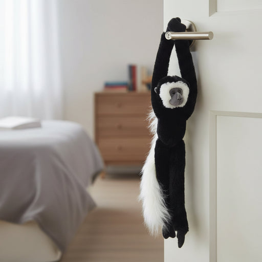 Plush toy of a monkey hanging on a white background or at the door
