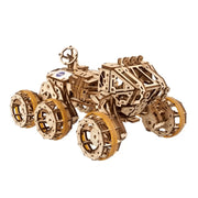 NASA-themed mechanical models packaging on a wooden surface Wooden model tractor kit on a white background