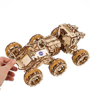 NASA-themed mechanical models packaging on a wooden surface Wooden model of a rover with NASA logo on a white background