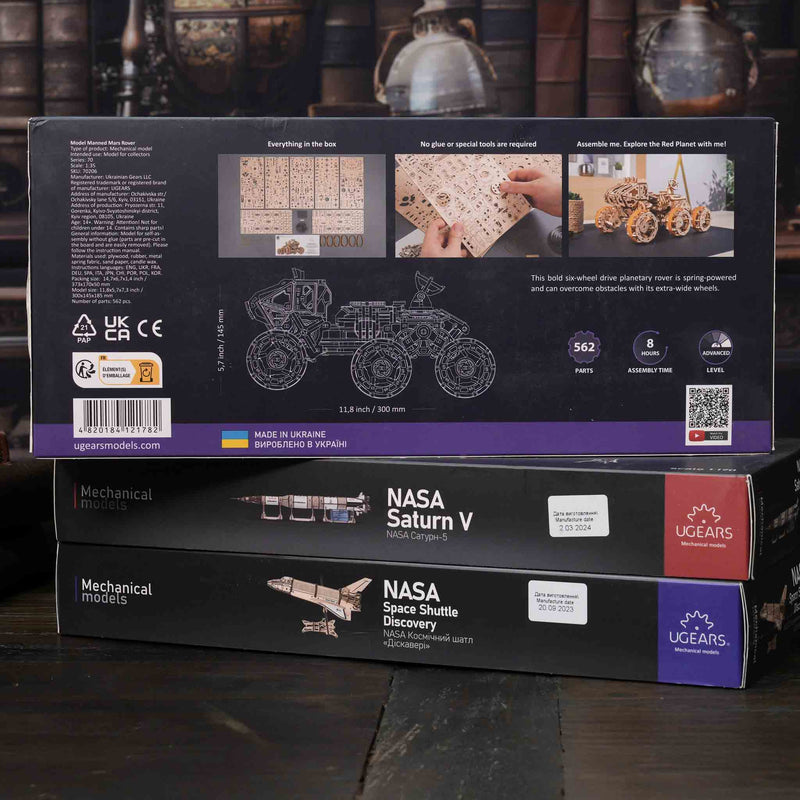 NASA-themed mechanical models packaging on a wooden surface
