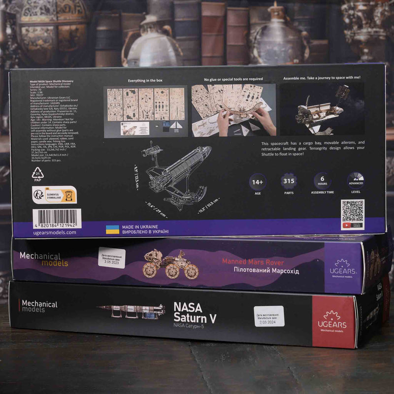 NASA Saturn V model kit packaging with detailed illustrations on a dark background