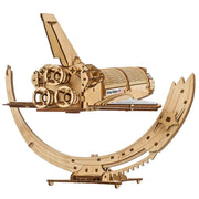 NASA-themed mechanical models packaging on a wooden surface Wooden model kit of a rocket ship on a white background