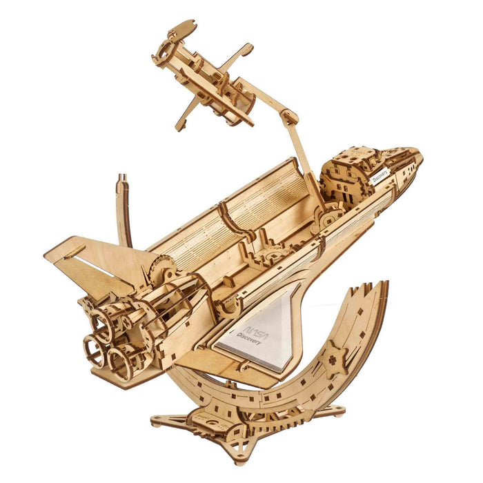 NASA-themed mechanical models packaging on a wooden surface Wooden model ship puzzle on a white background