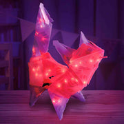 Red and white LED light-up toy on a wooden surface with a dark background