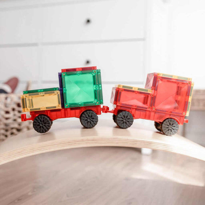 Colorful toy train cars on a wooden track with a blurred background Connetix magnetic tiles