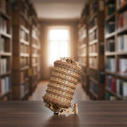 Ugears Escapewelt Cryptex Wooden letterpress wheel Wooden model of the Leaning Tower of Pisa on a table with bookshelves in the background
