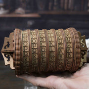 Ugears Escapewelt Cryptex Wooden letterpress wheel held in a hand with a blurred background