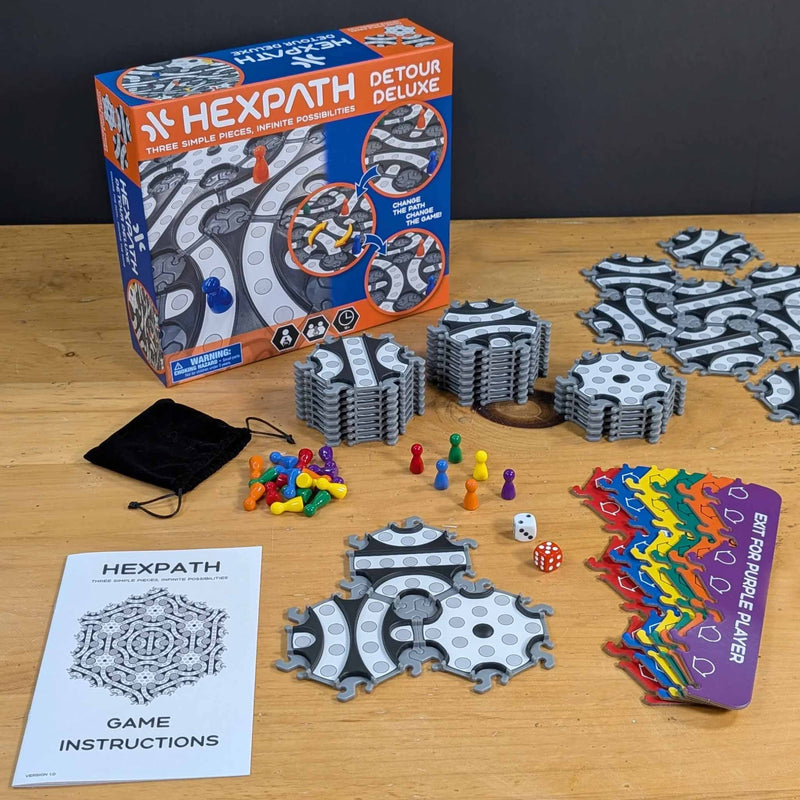 Hexpath Detour Deluxe game components on a wooden table