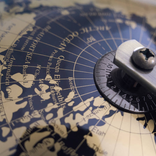 Vintage-style globe map with a compass rose on a wooden surface