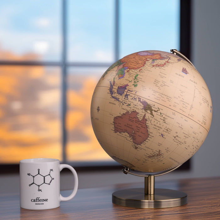 Globe and mug on a desk with a blurred window background