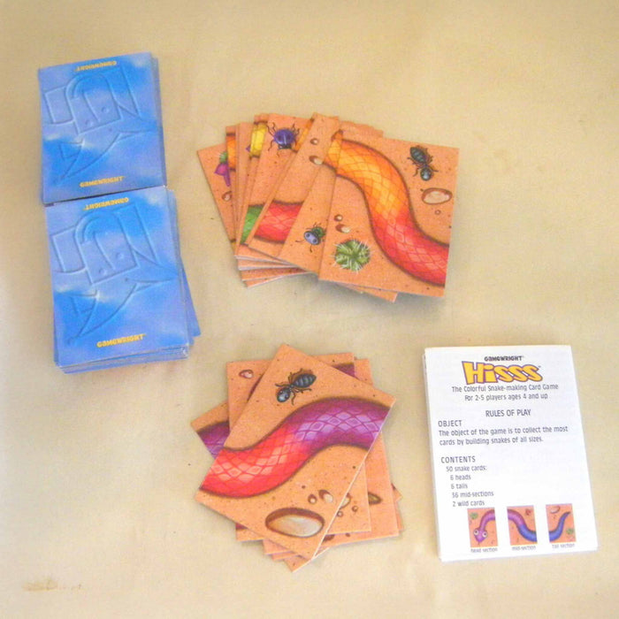 Card game with colorful cards and blue packaging on a beige surface