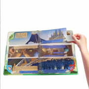Children's educational book with colorful illustrations and a hand pointing to a page.