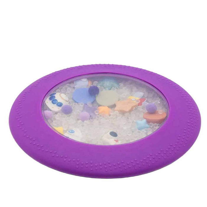 Purple frisbee with colorful sea creature toys and water beads on a white background