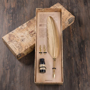 Feather pen set with ink bottle in a decorative box on a wooden surface