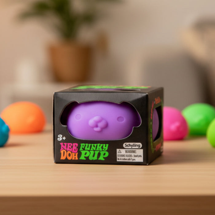 Purple 'Funky Doh Pup' toy in packaging on a wooden surface with colorful balls in the background.