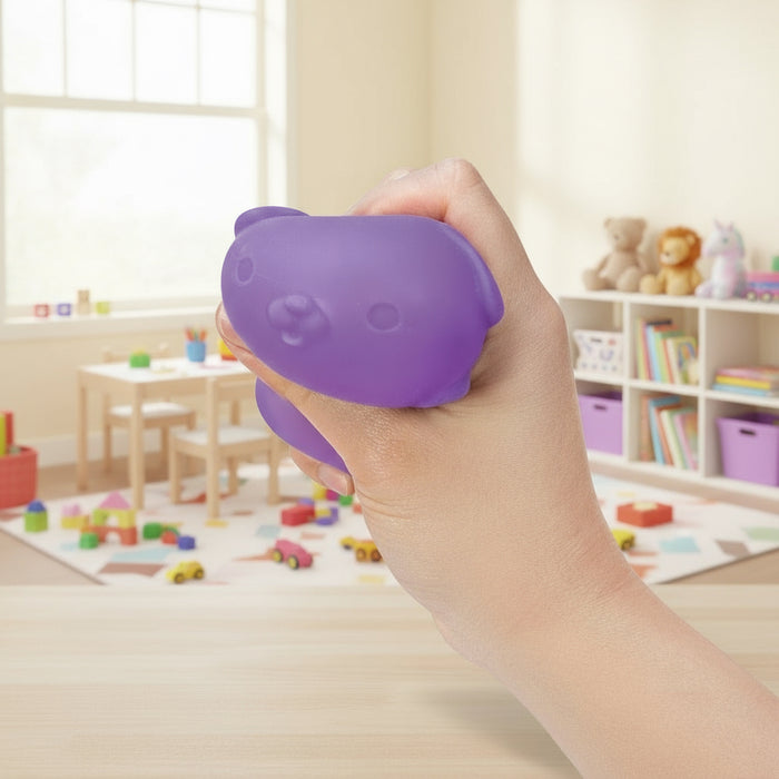 Hand holding a purple bear-shaped stress ball in a classroom setting