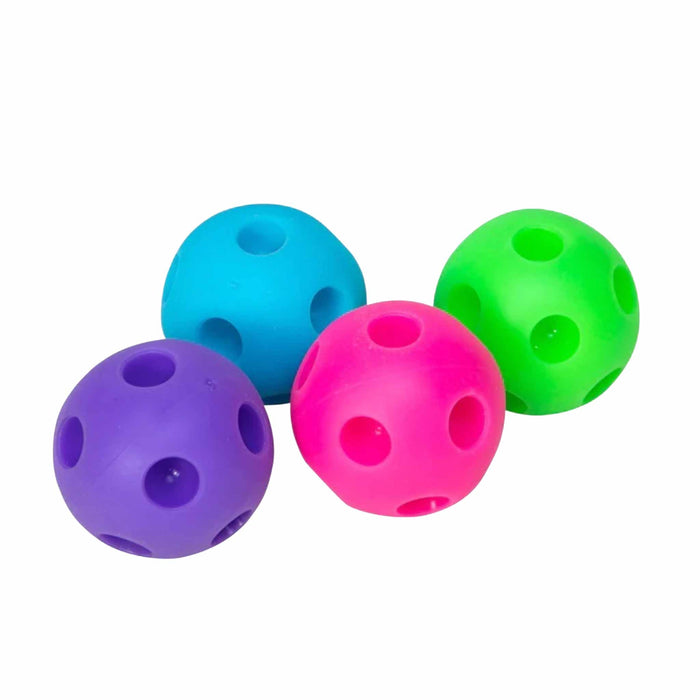 Four colorful plastic balls with holes on a white background