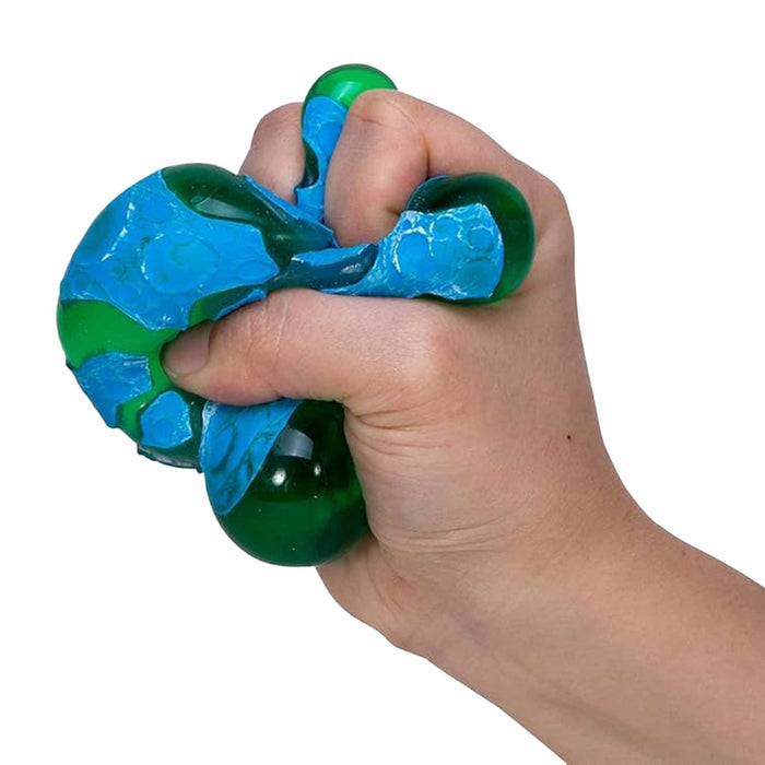 Hand holding a blue and green stress ball against a white background