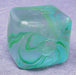 Marbled green and blue cube swirl needoh object on a textured gray background