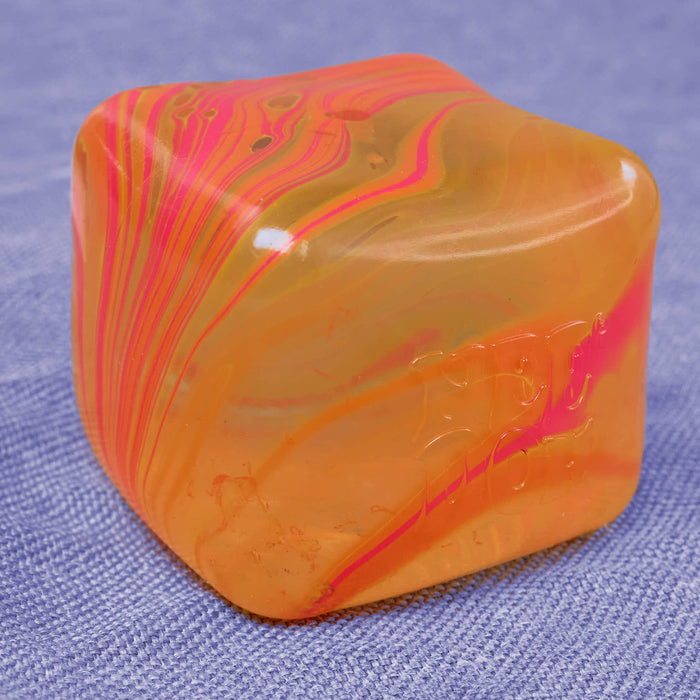 Marbled orange and pink cube swirl on a textured blue background