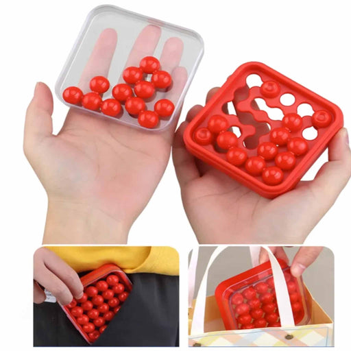 Red silicone mold with small compartments held in hands against a white background