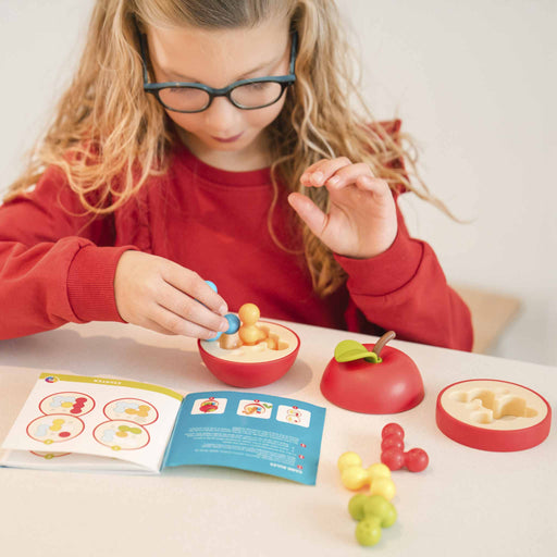 Child playing with educational toys and a book on a table