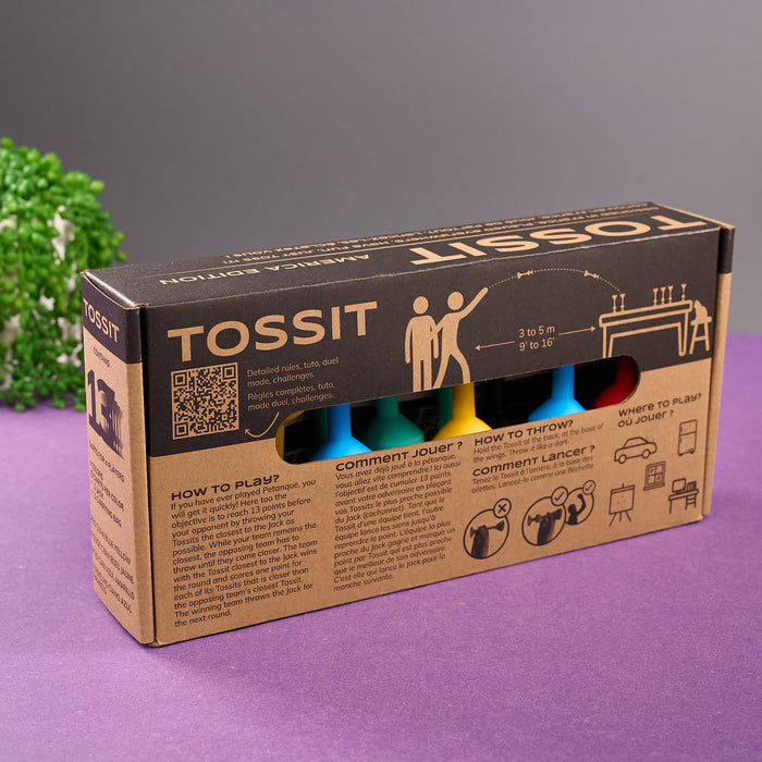 Cardboard box packaging for TOSSIT product on a purple surface with a gray background