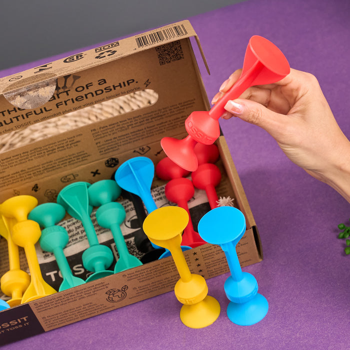 Cardboard packaging of TOSSIT product with colorful elements and text.