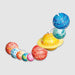 STEAM Powered Kids Solar System A set of colorful, planet-shaped hanging ornaments or decorations arranged in a curved row on a light gray background. The planets feature various patterns like glitter, stars, stripes, and polka dots in vibrant colors including blue, yellow, red, orange, green, and pink.