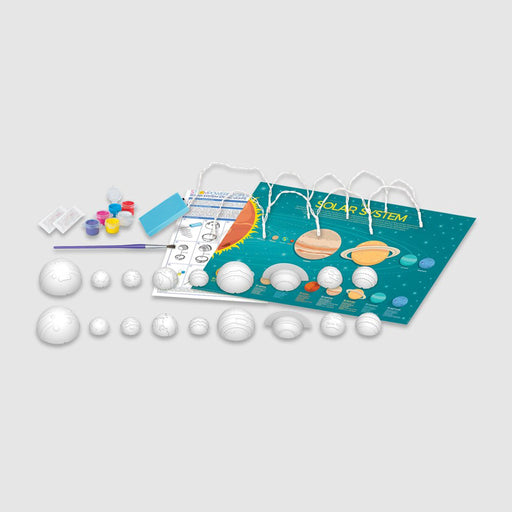 STEAM Powered Kids Solar System model kit with white plastic planet models, small paint pots, a paintbrush, and a printed solar system chart on a light gray background.
