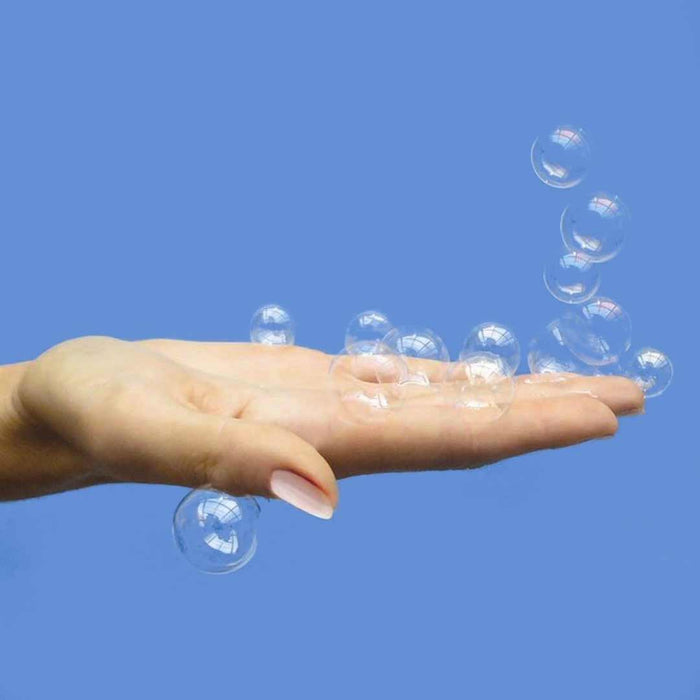 Hand with soap bubbles against a clear blue sky
