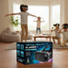 A boxed pair of virtual reality glasses sits on a wooden table in the foreground, with a blurred living-room scene behind it showing children wearing the VR glasses and playing.