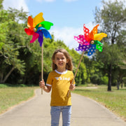 Child holding colorful pinwheels in a park