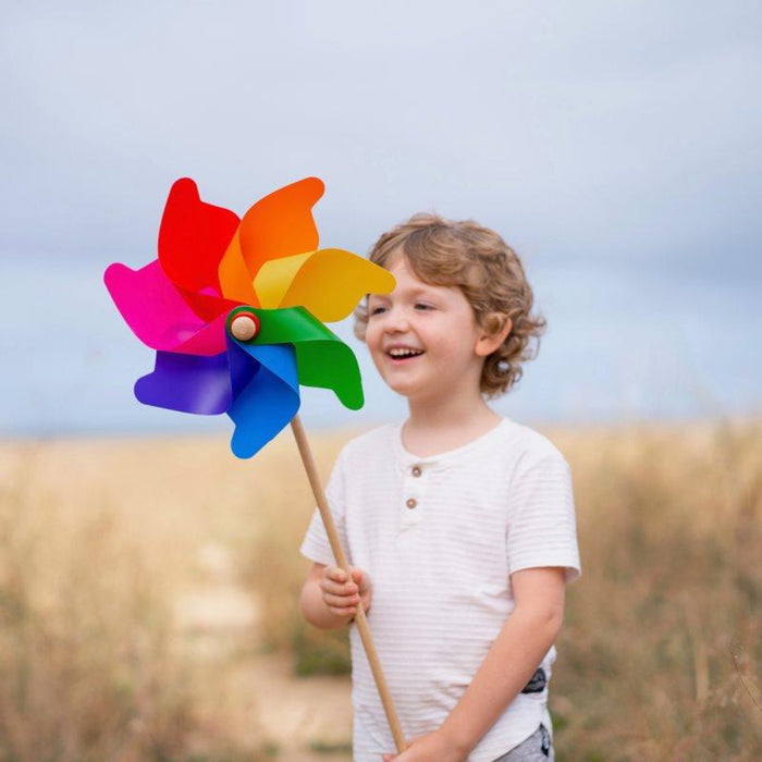 Child holding a colorful pinwheel in an outdoor setting