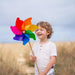 Child holding a colorful pinwheel in an outdoor setting