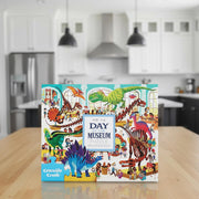 Crocodile Creek Day at the Museum Puzzle box, featuring a colorful, busy illustration of dinosaurs and children exploring a museum.