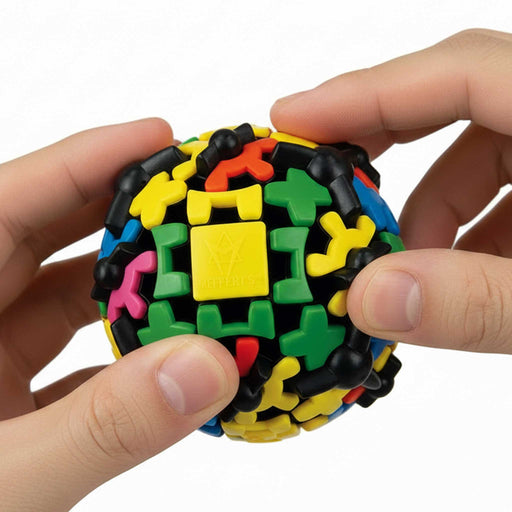 Colorful puzzle ball held by a hand against a white background