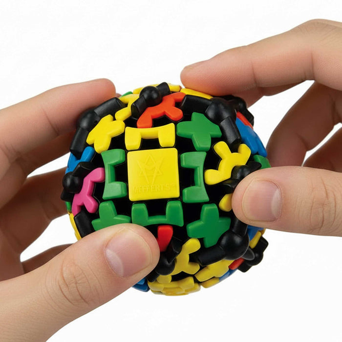 Colorful puzzle ball held by a hand against a white background