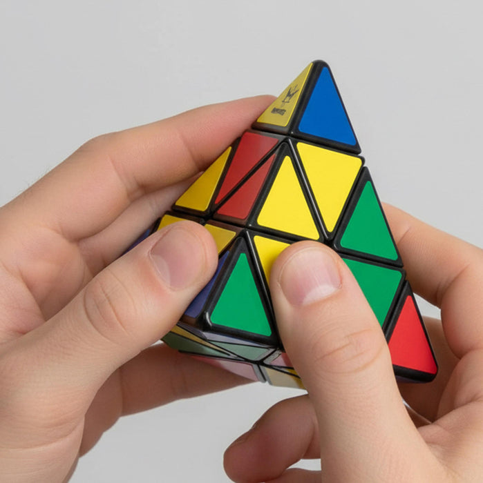 Person solving a Rubik's Pyramid puzzle with a plain background