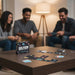 A board game called SELFISH is displayed on a wooden table in a cozy living room setting, with its box standing upright and several cards spread out. Two men and a woman are seated in the background, smiling and holding game controllers, creating a warm and engaging atmosphere.