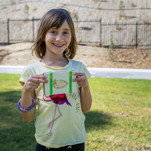 girl holding a set of pressed flower cards The cards have white paper inserts with pressed flowers on brown kraft backing, and one wooden board has a green ribbon handle and the words 'Mrs Green' printed on it.