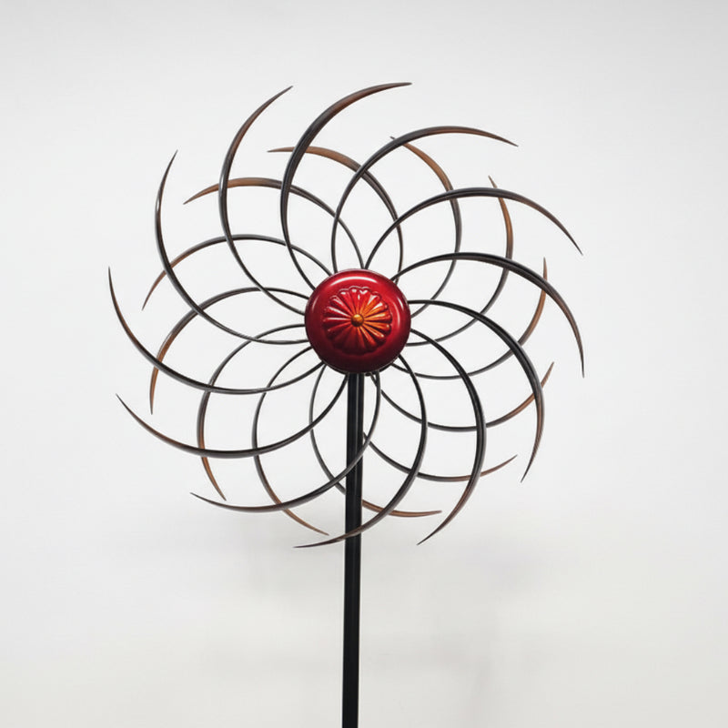 Decorative metal windmill with a red center on a white background